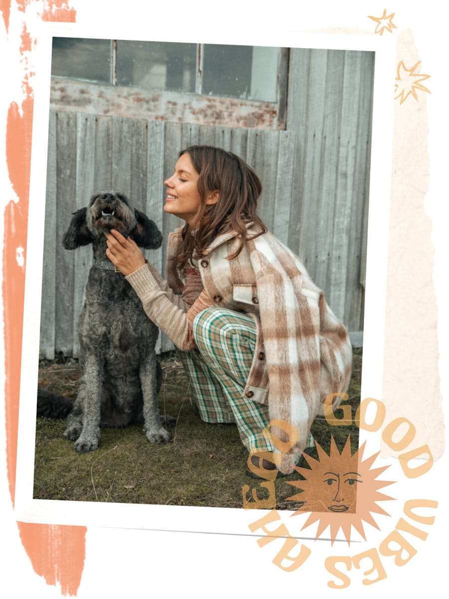 Collage of images and graphics. Image sits in white frame, she is wearing the symphony pants with the Birkin Jacket as she crouches down to pat a black fluffy dog. 