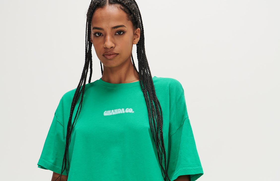 Female model wearing the thrift tee in T rex green