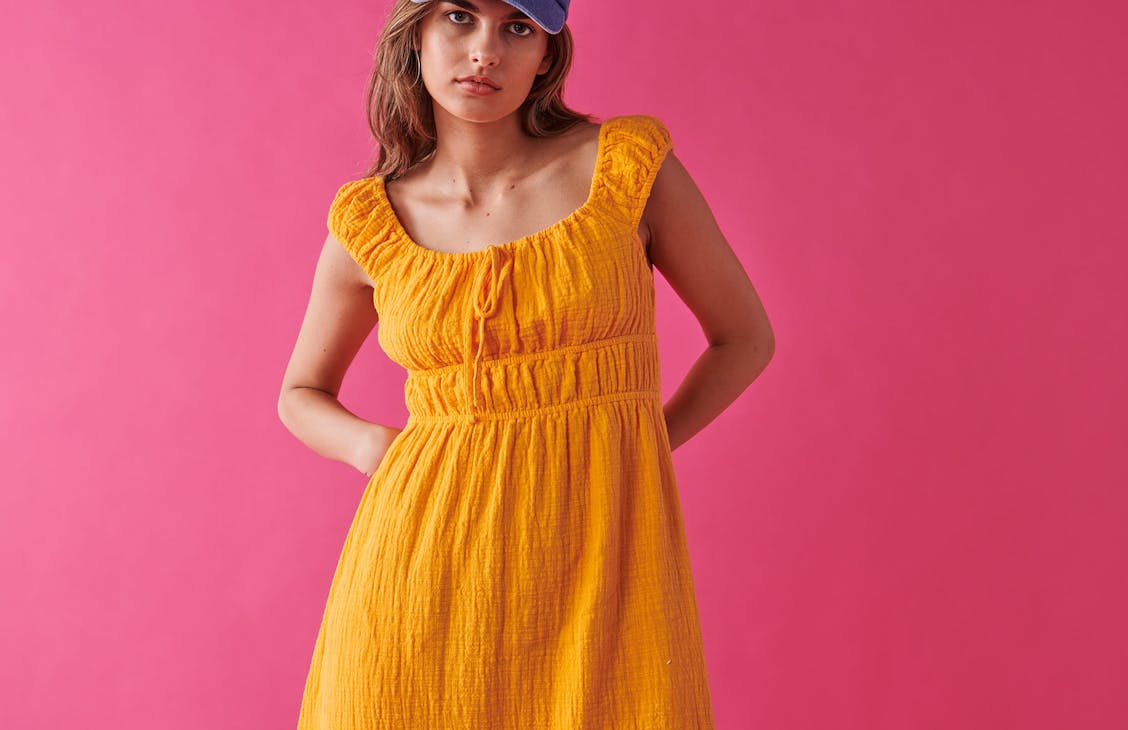 Female model wearing the Peggy Maxi Dress in Tango Orange. 