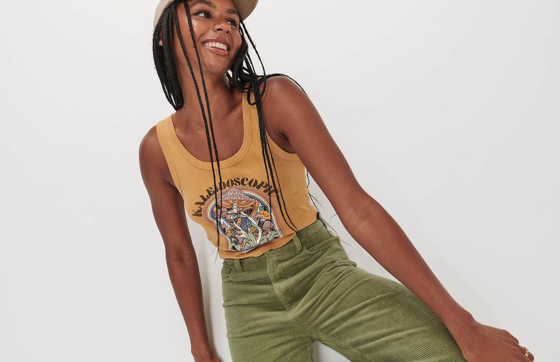Female model wearing the Kaleidoscope Tropics Tight Singlet in desert yellow. 