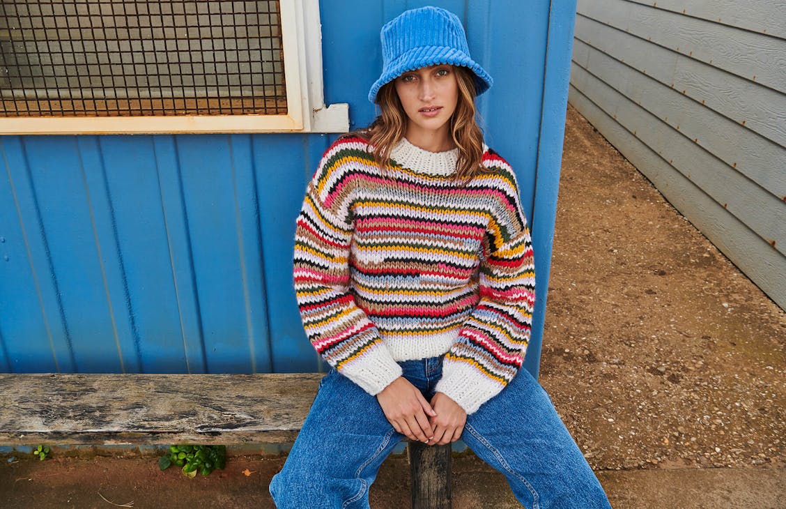 Female model wearing the Urban Knit in all sort stripe.