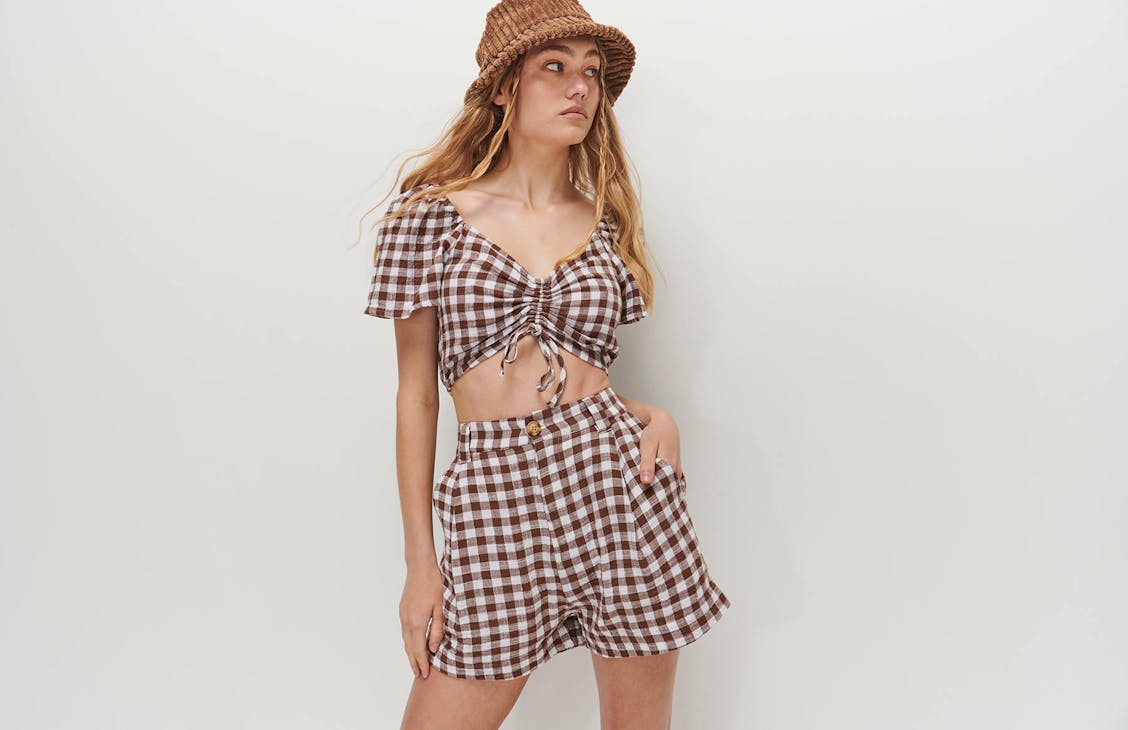 Female model wearing the Oxford shorts in bark check.