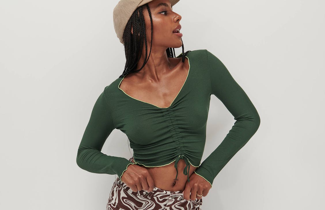 Female model wearing the reverse Emily long sleeve in cilantro.