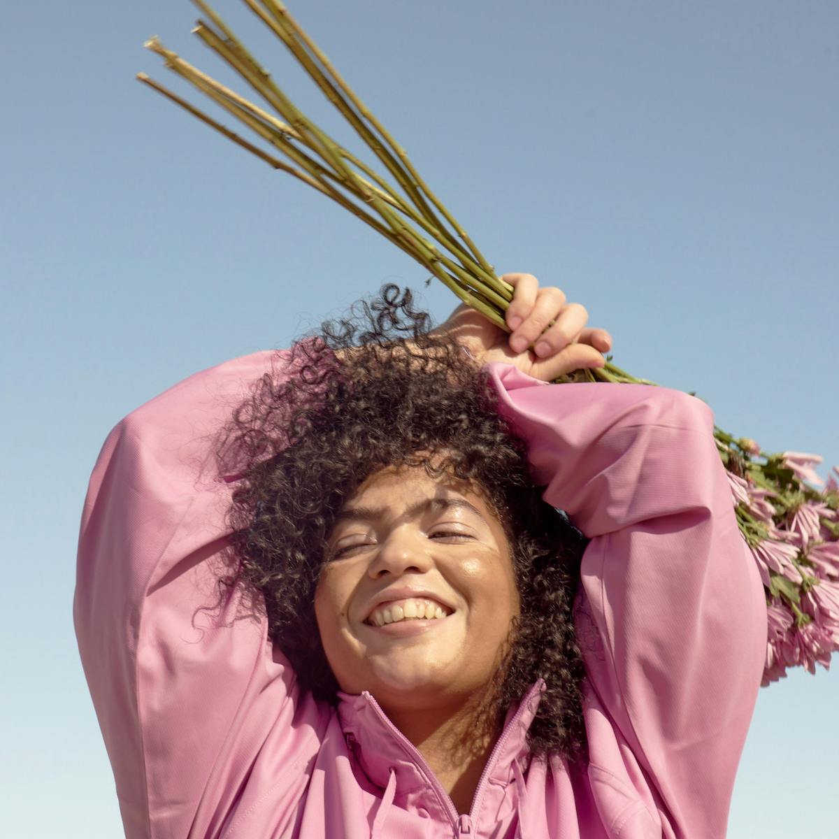 Woman wearing Girlfriend Collective holding flowers