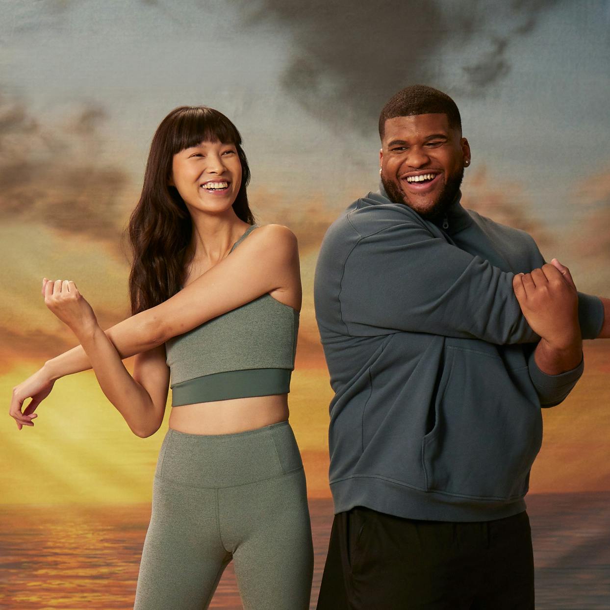 Man and woman stretching wearing Girlfriend Collective