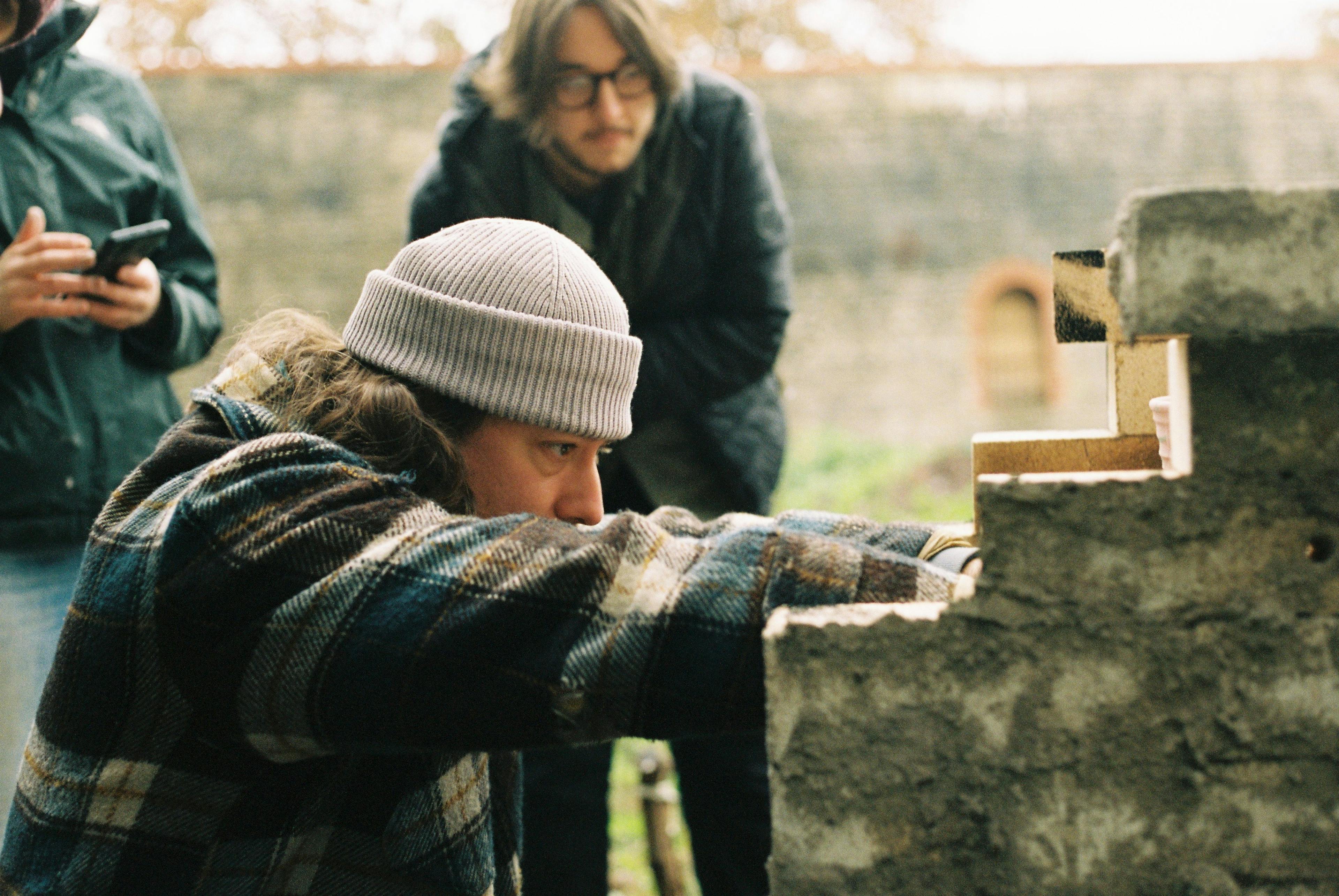 Portrait of Phil Root. He is loading a wood fired ceramic kiln. 