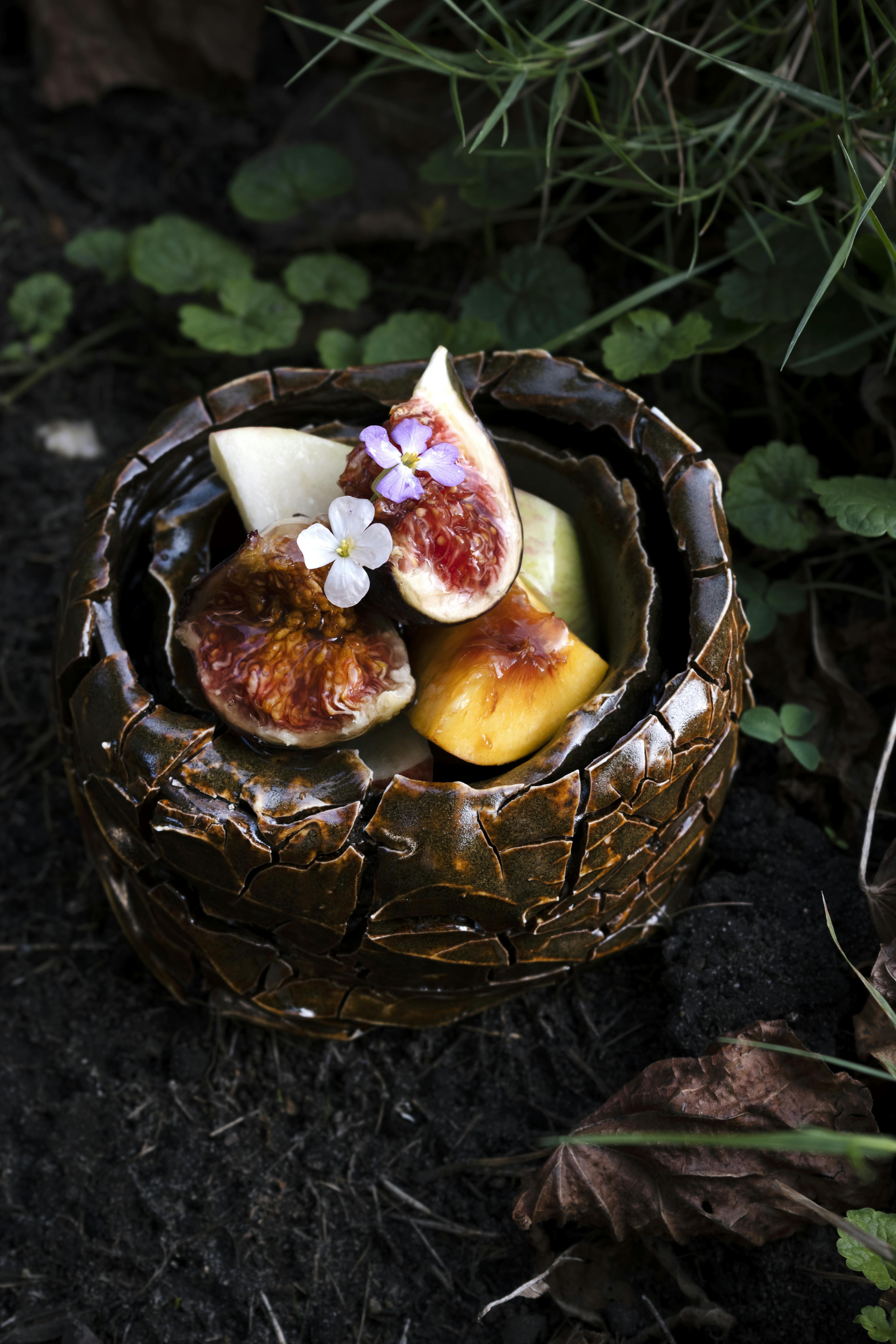 A plate created by Steven Sales using local and recycled clay and ceramic glaze materials. Plate has figs inside it. 