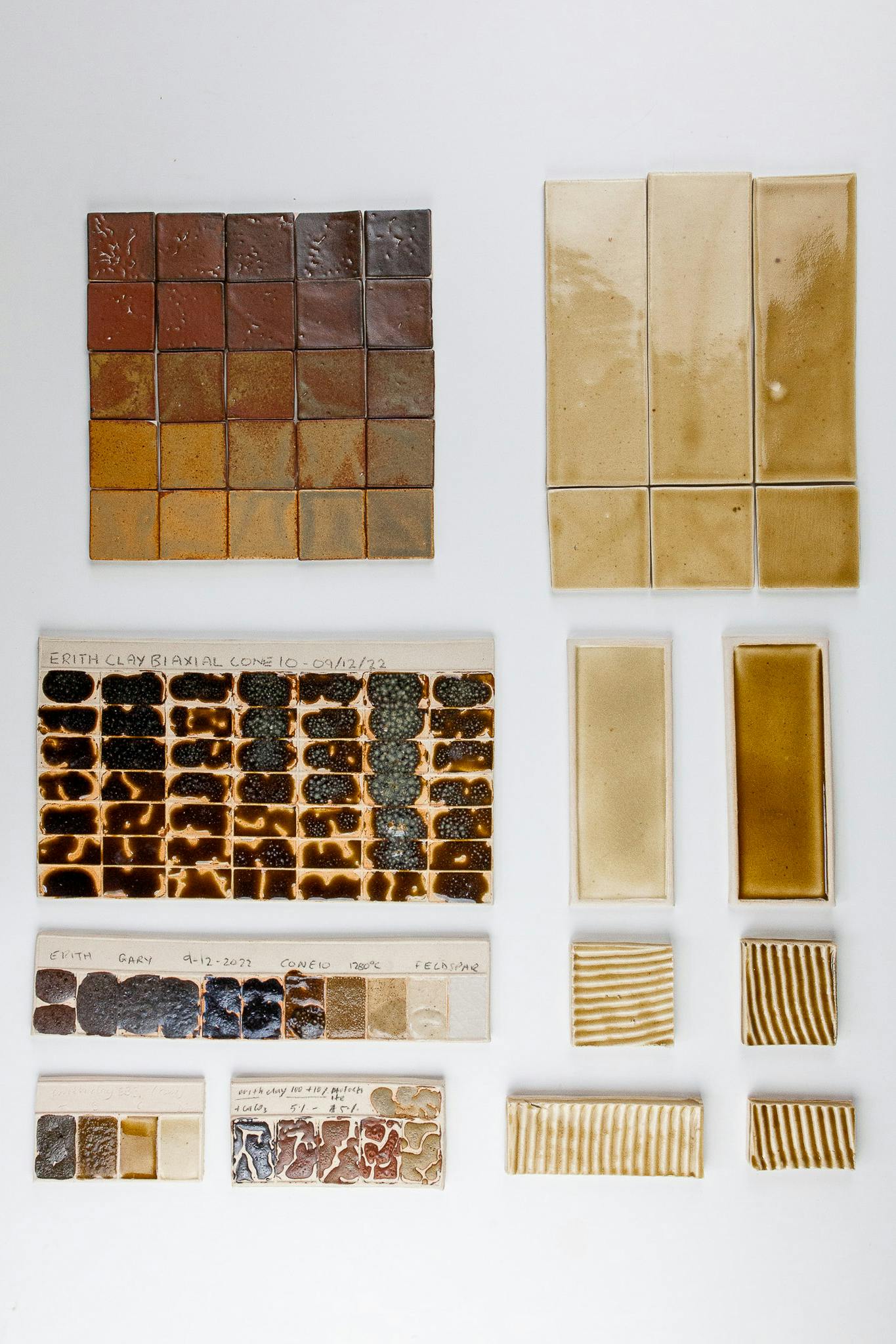 A set of ceramic test tiles. They are of warm brown, honey and ochre tones. These tiles wee made using waste materials collected in Erith Londond