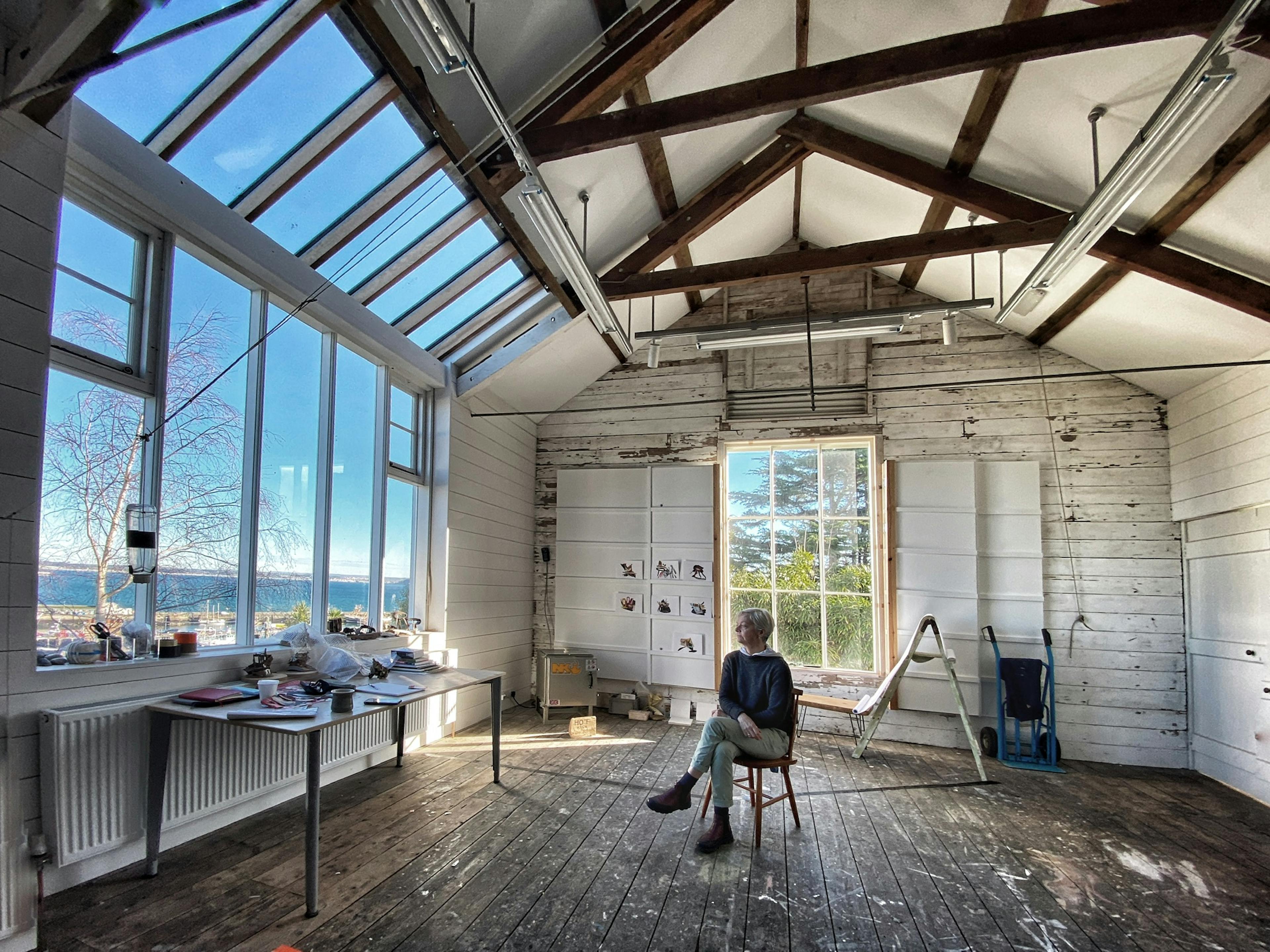 A studio shot with gret big skylight and an artis sitting in the middle of the space. 