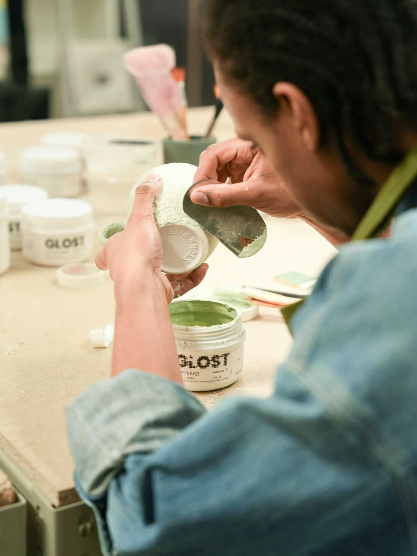 A person carefully working on their glaze project