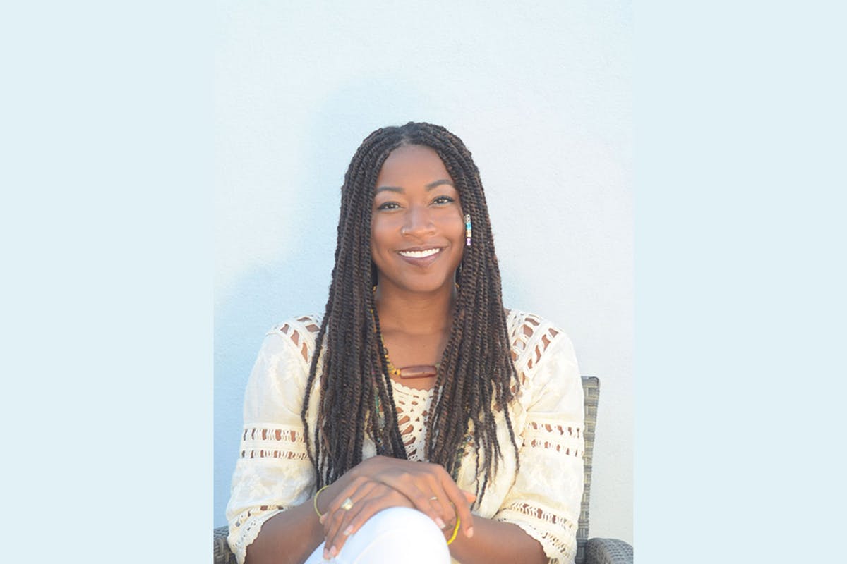 Seated African American woman smiling into the camera.