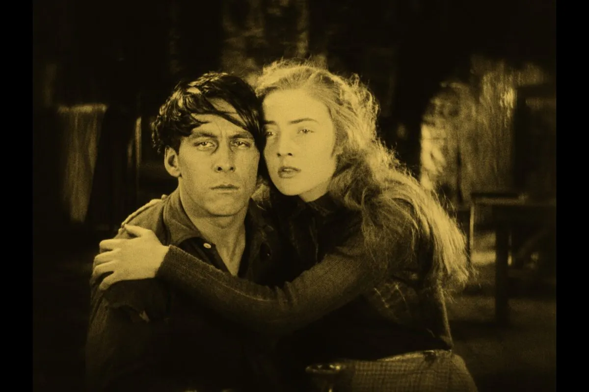 An unhappy looking man and woman. The woman is putting her arm around the man.