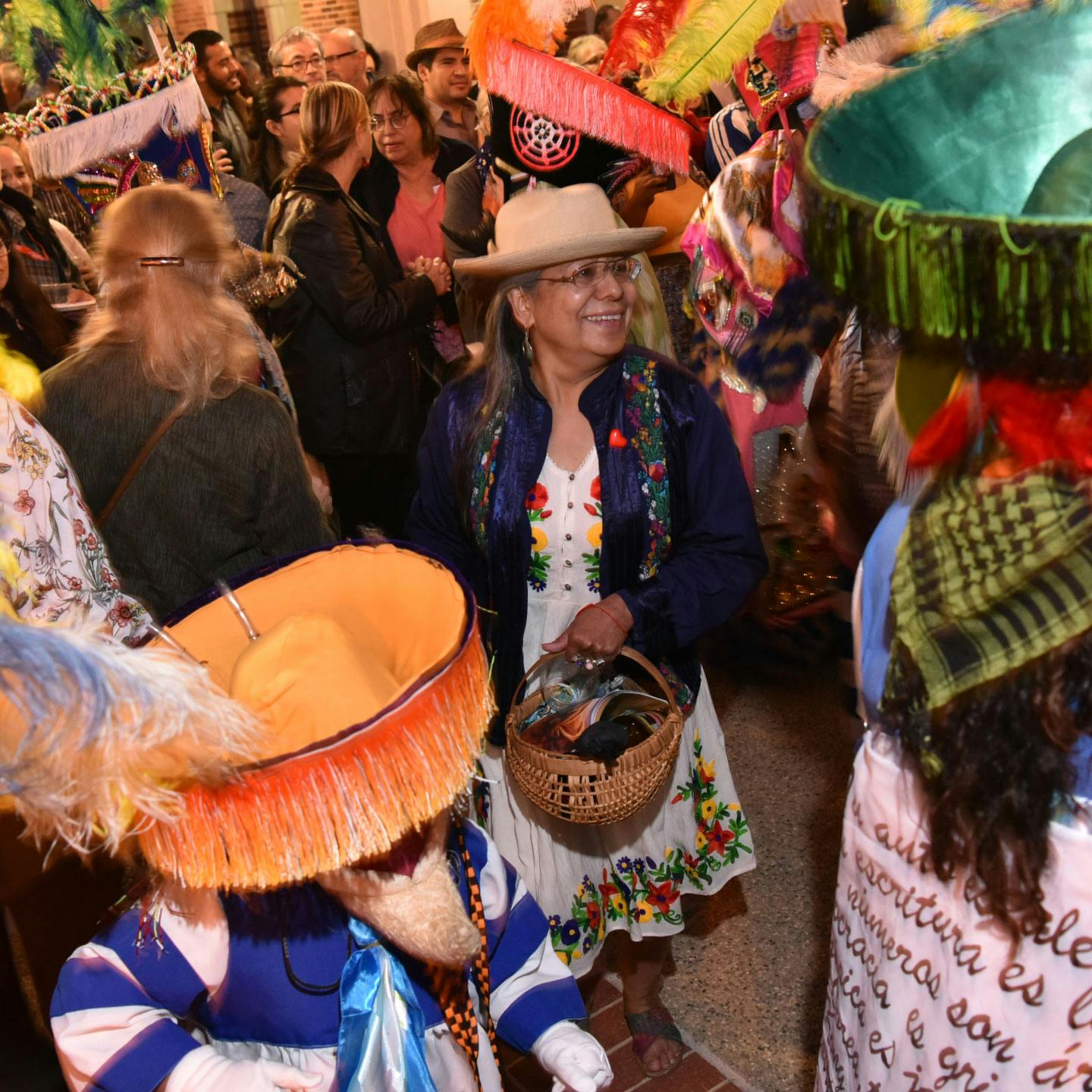 A woman smiling amongst a crowd.