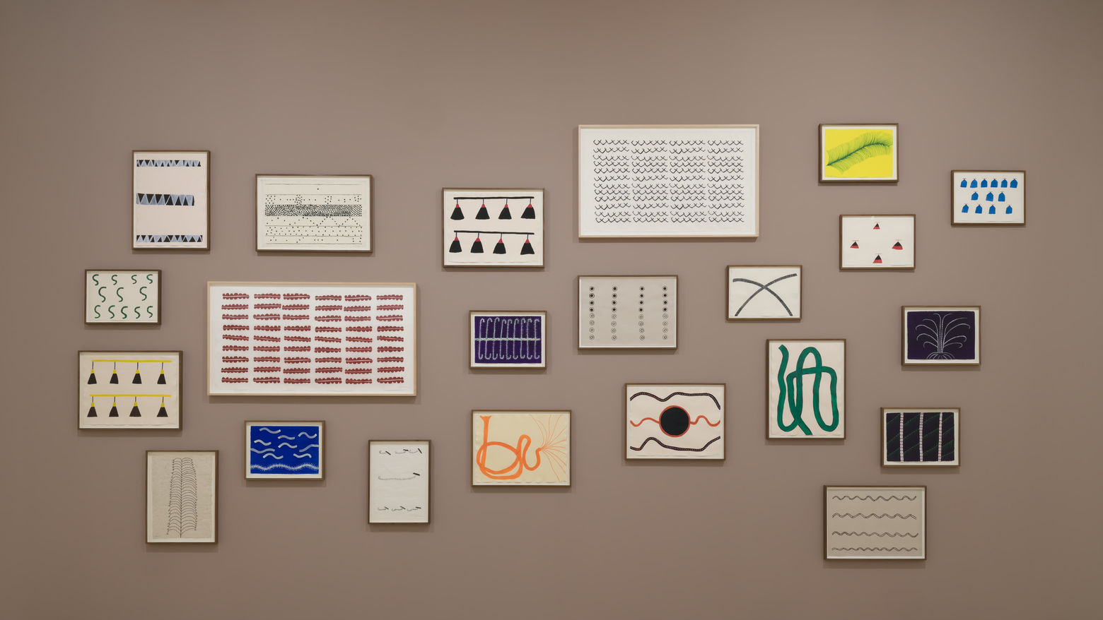Gallery wall with a series of works featuring interesting shapes in frames
