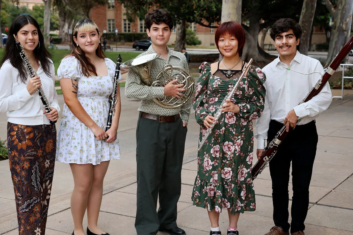 A quintet of musicians pose with their instruments