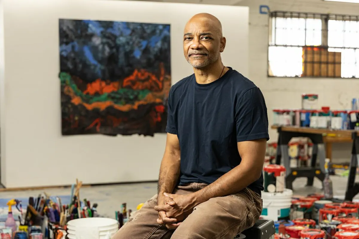 Portrait of Rodney McMillian in his studio surrounded by paint, brushes and canvas