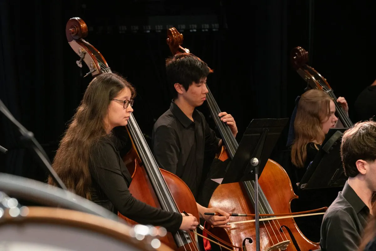 Close up of two standup bass players performing with the UCLA Symphony