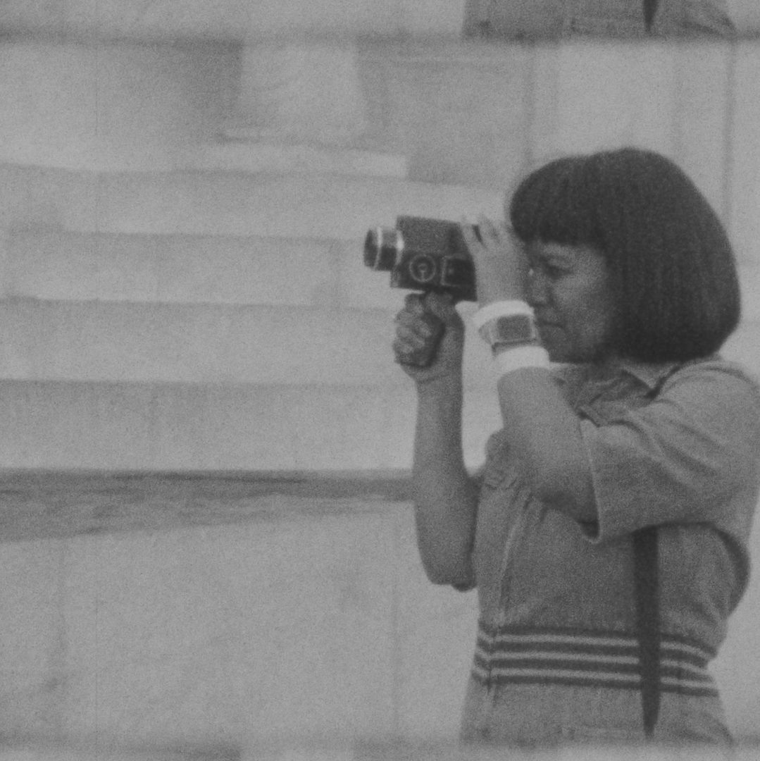 Abegaze looking into a small camera