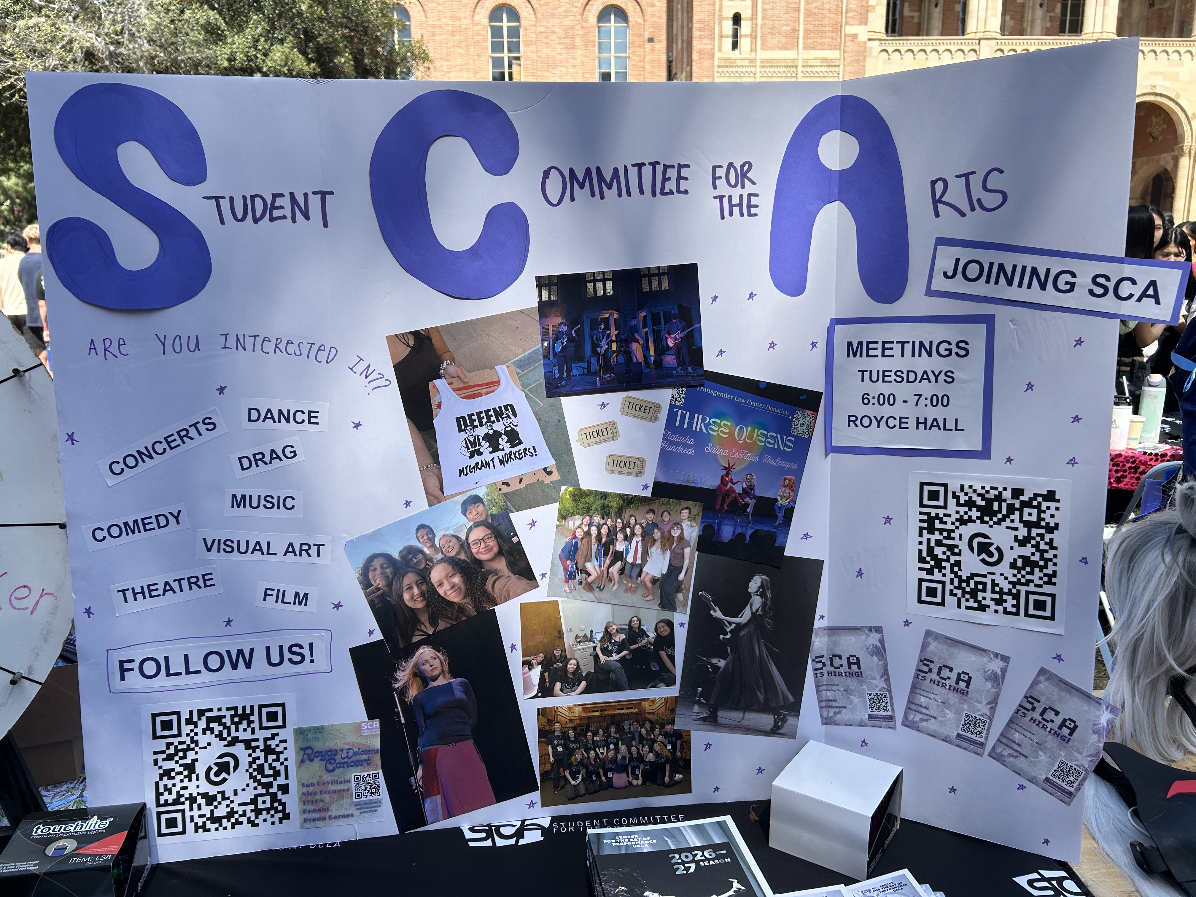 A handmade sign with photos and messages encouraging students to get involved with a campus arts group