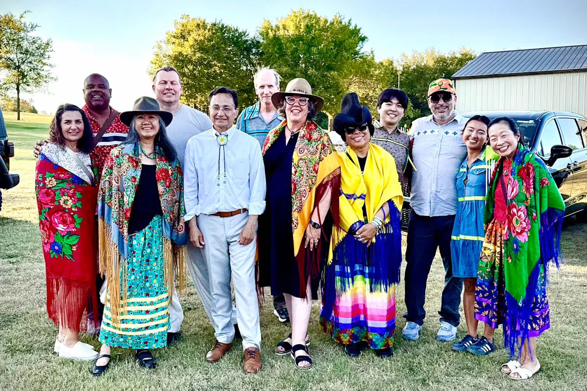 A group of people pose in vibrant clothing