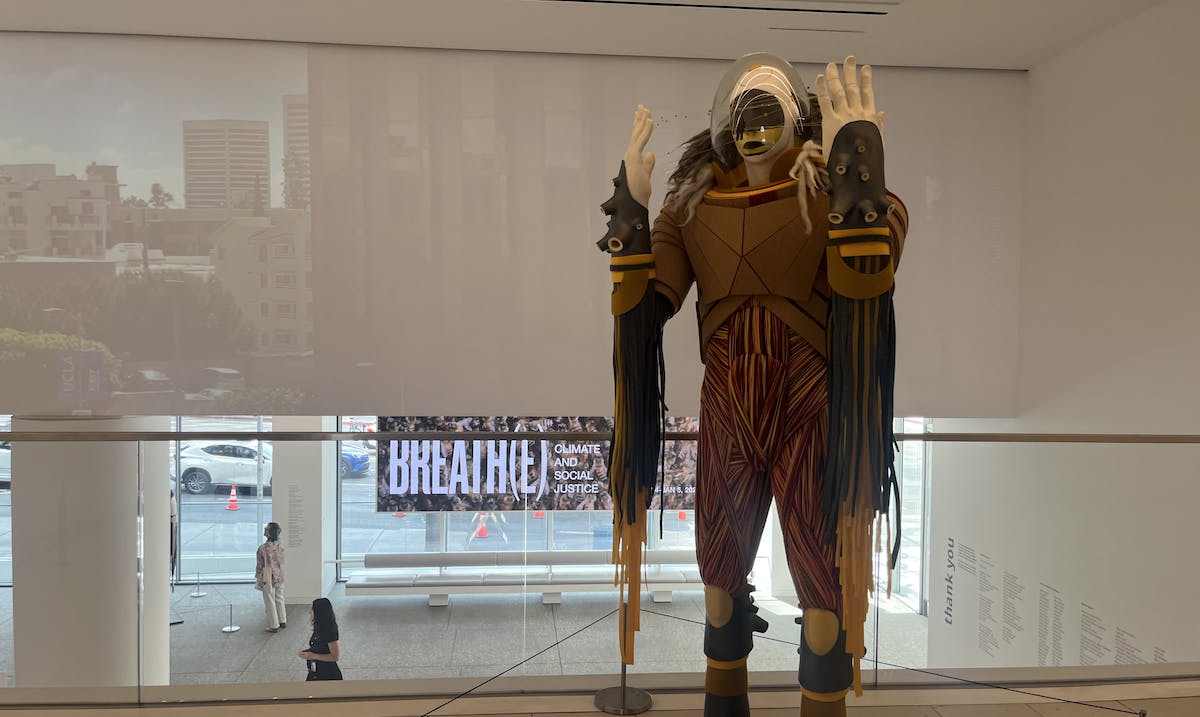 A large sculpture meant to represent an indigenous space traveler made of yarn and cork and other materials stands in the Hammer Museum. 