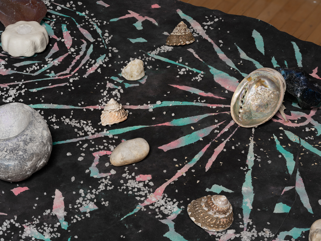 detail view of art by mercedes dorame using paint, stones and shells in a cosmic pattern
