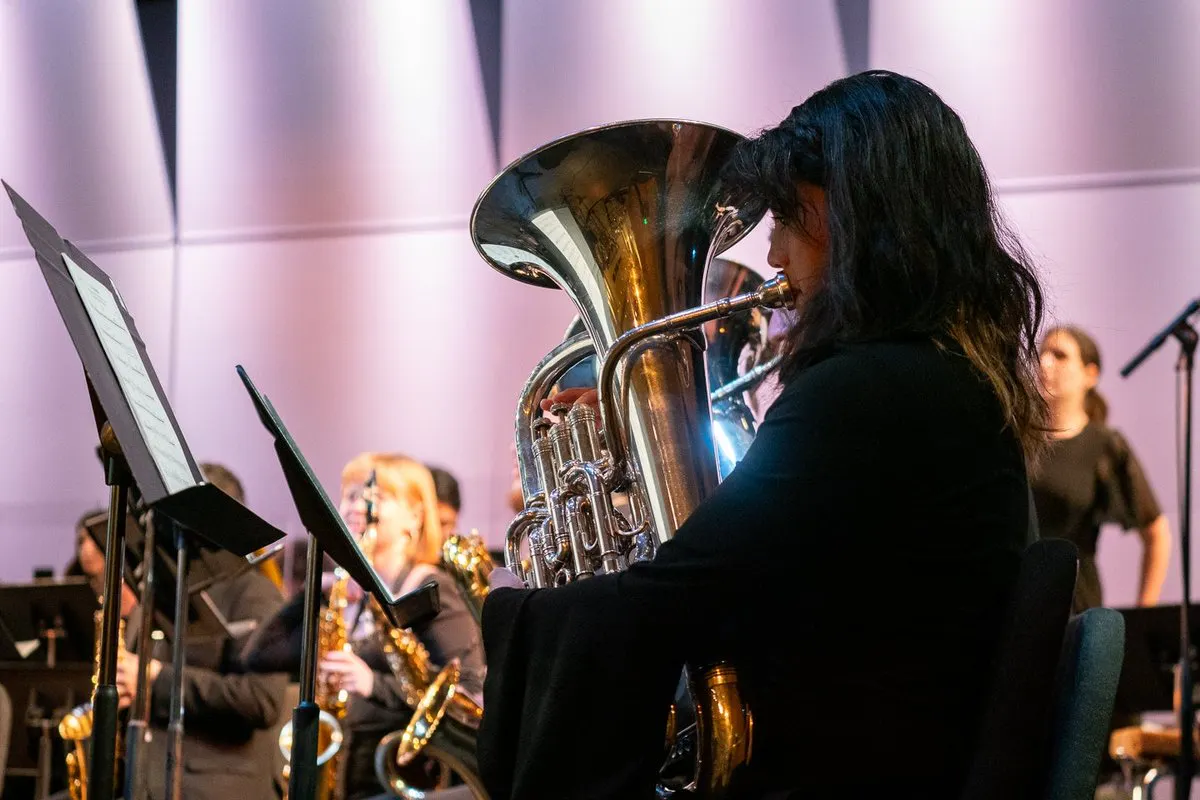Closeup of tuba performer among an orchestra onstage