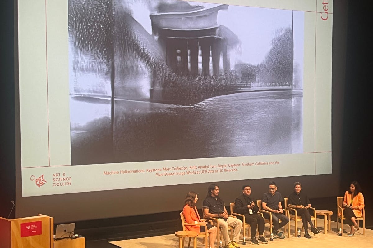 A still from a piece by Refik Anadol is shown on a screen behind a panel of artists.