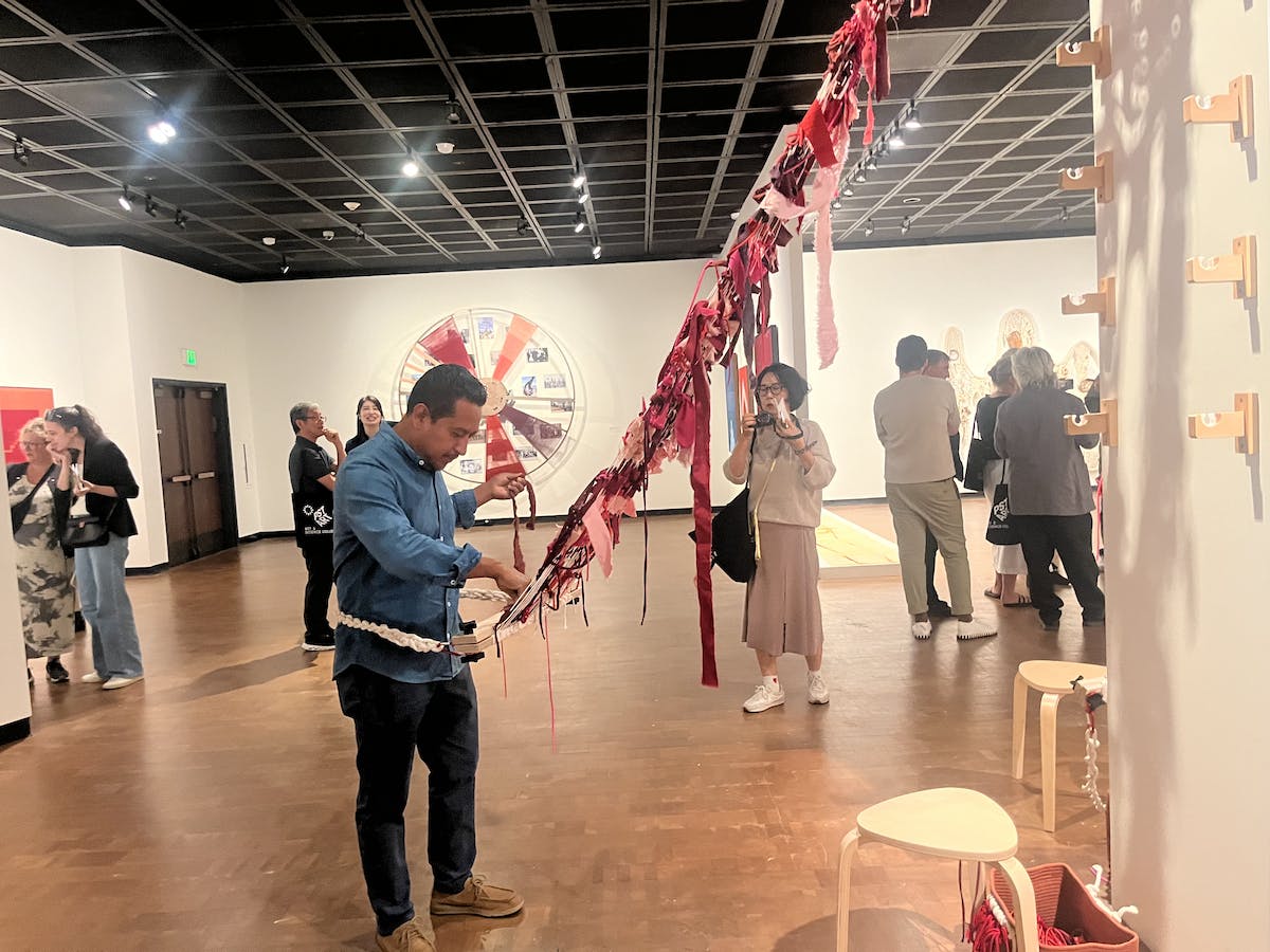 Textile artist Porfirio Gutiérrez weaves in the gallery at the Fowler Museum 