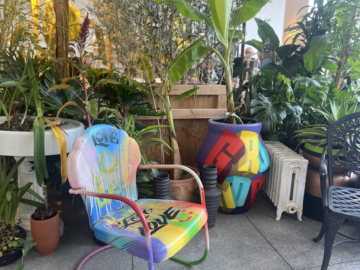 Colorful chairs nestled in between planters at the Hammer Museum as part of a Ron Finley garden