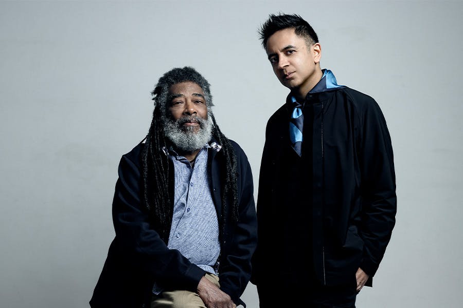 Vijay Iyer and Wadada Leo Smith pose in front of a gray background
