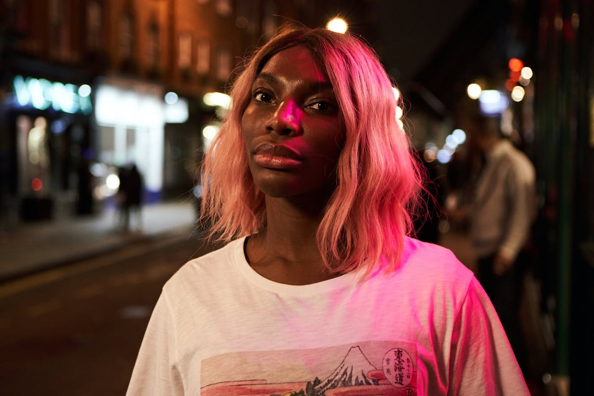 A person on a dimly lit street looking into the camera