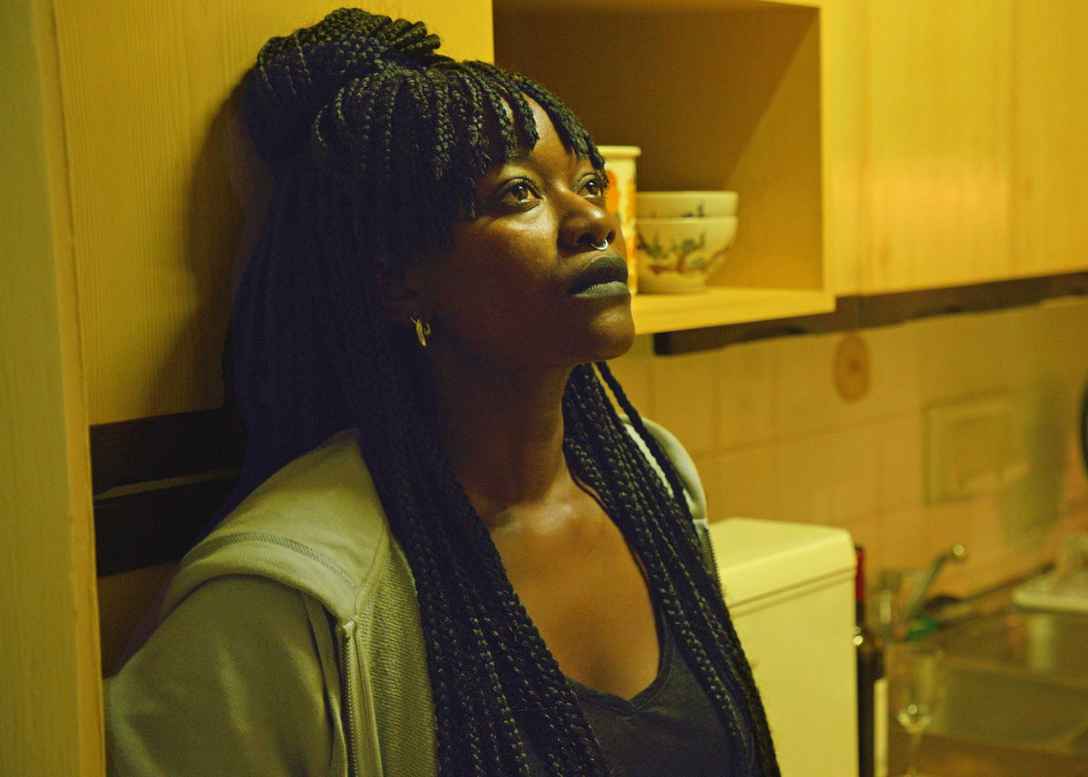 A woman in thought leaning against the wall