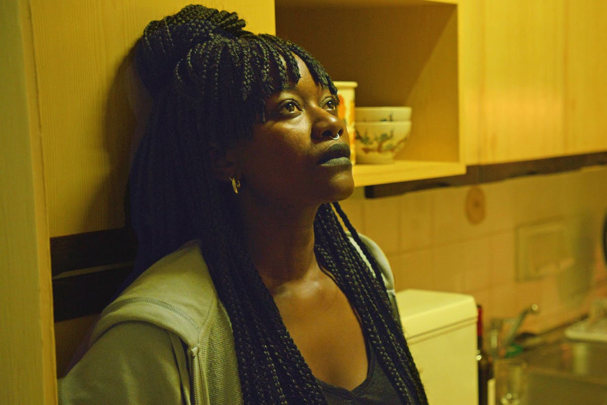 A woman in thought leaning against the wall