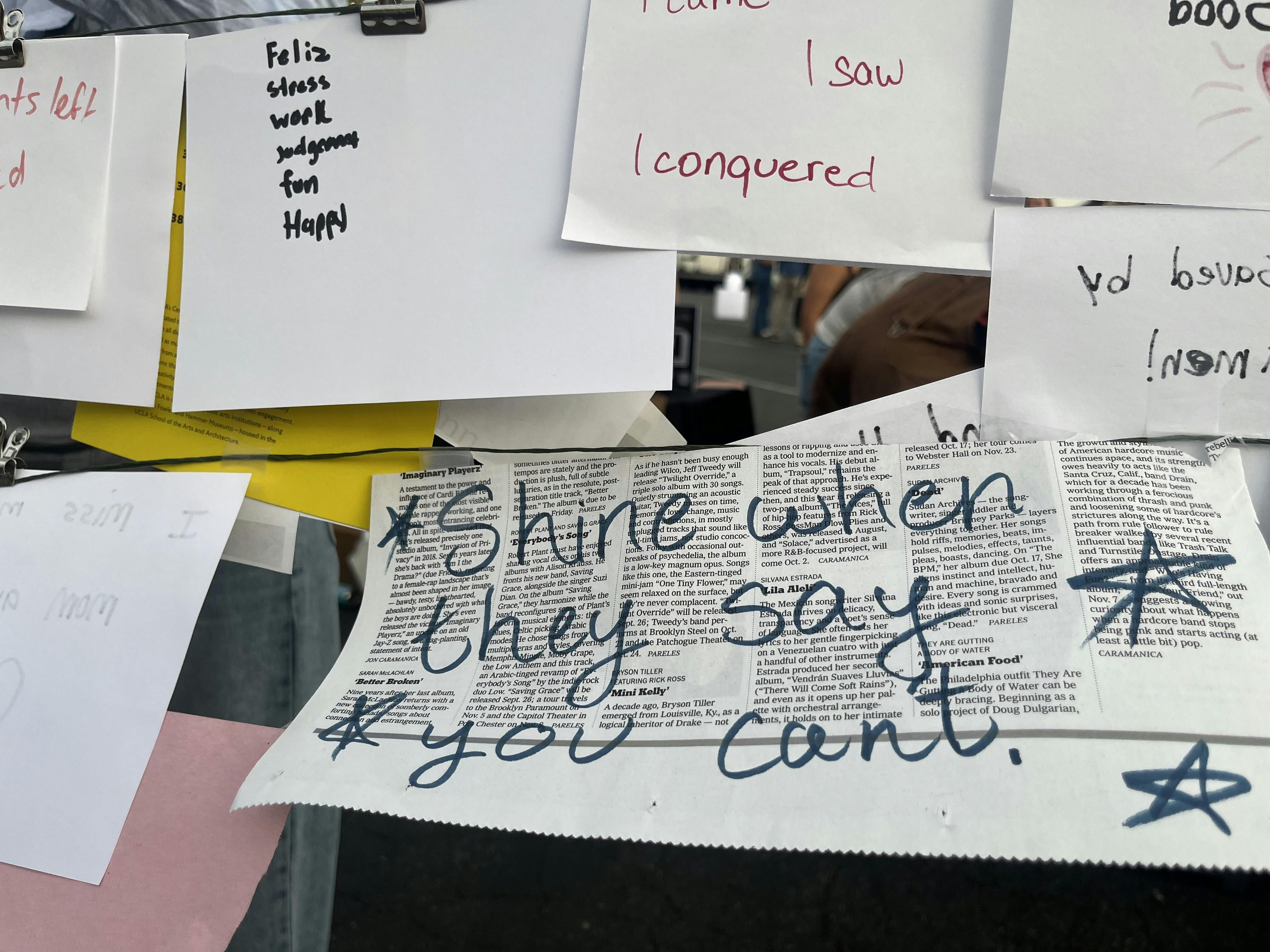 closeup of a display of six-word stories written by UCLA students. The story featured is handwritten on a piece of newsprint and says "shine when they say you can't"