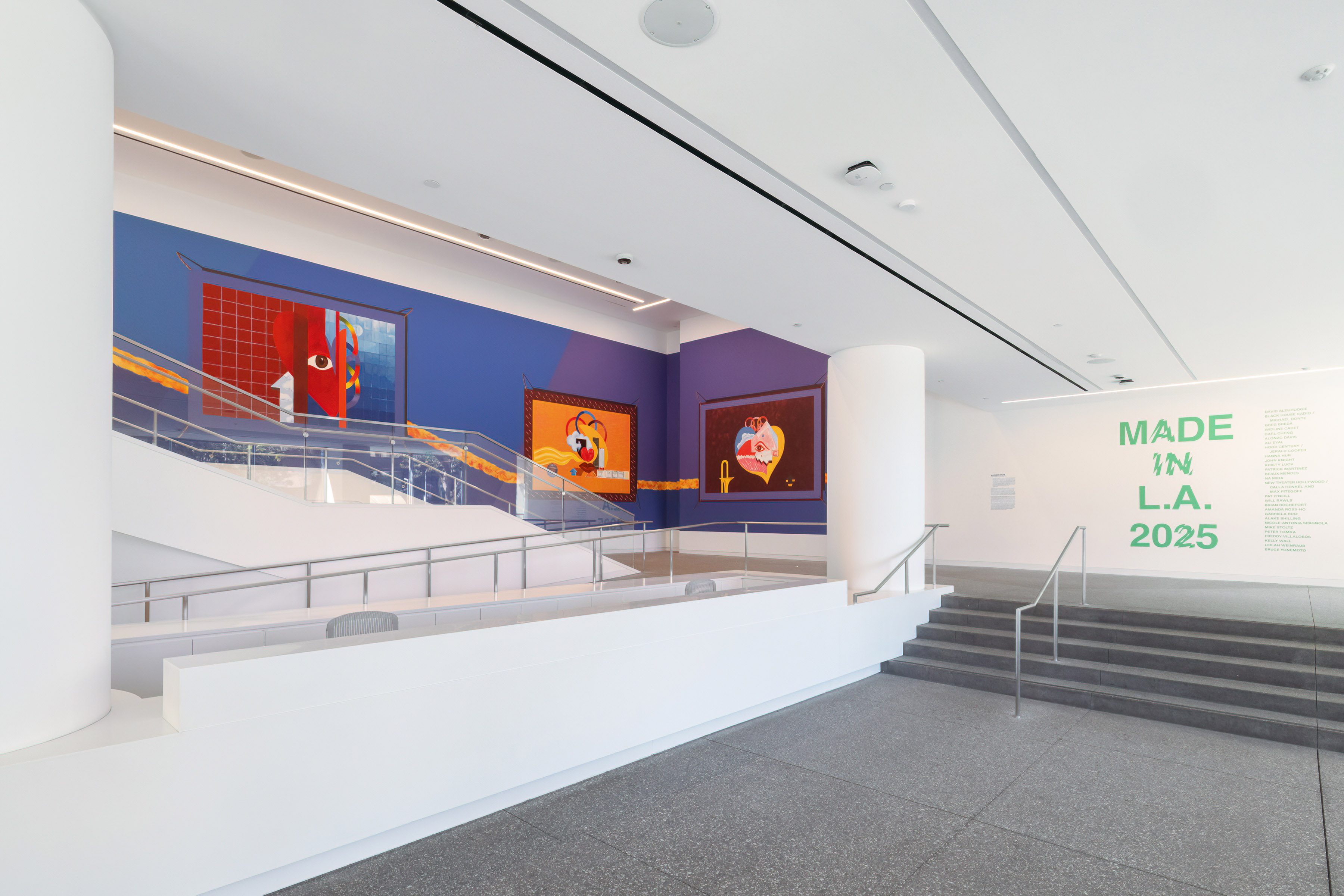 A view of the Hammer Museum gallery with a reproduction of Alonzo Davis murals, brightly colored with themes of hearts, eyes and Olympic rings
