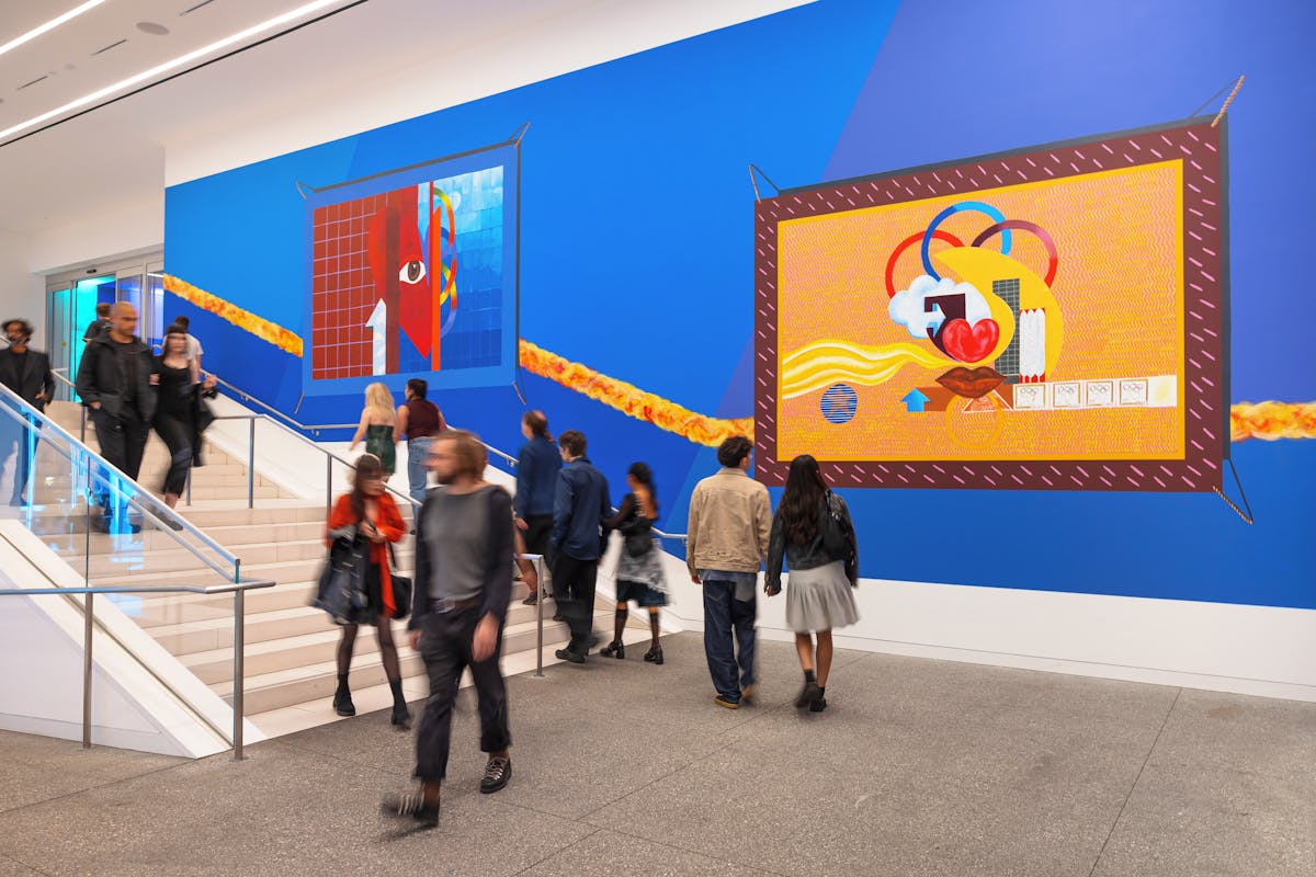 People move through the lobby of The Hammer Museum with large scale reproductions of a mural by artist Alonzo Davis. 