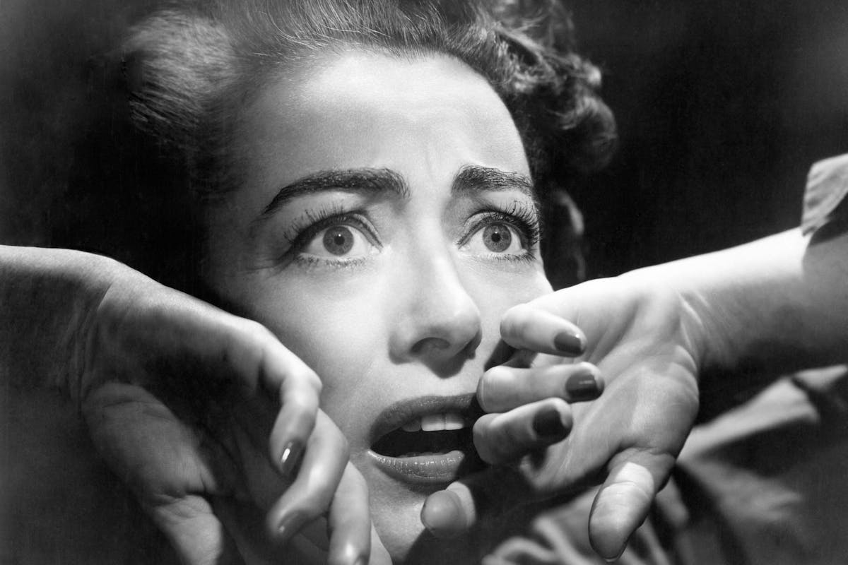 closeup on Joan Crawford's face showing fear