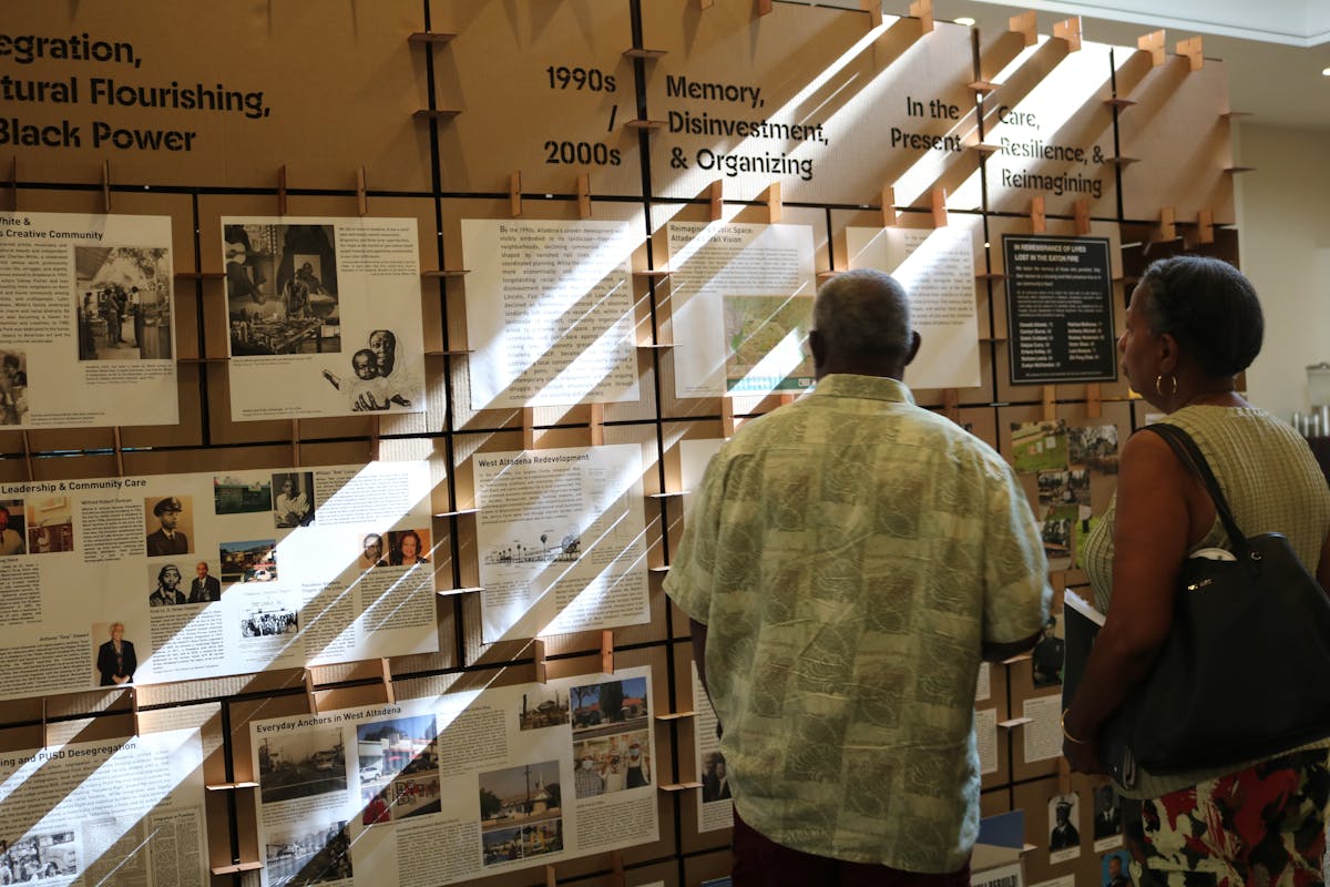 Visitors view an exhibition with images and text reflecting the history of Altadena