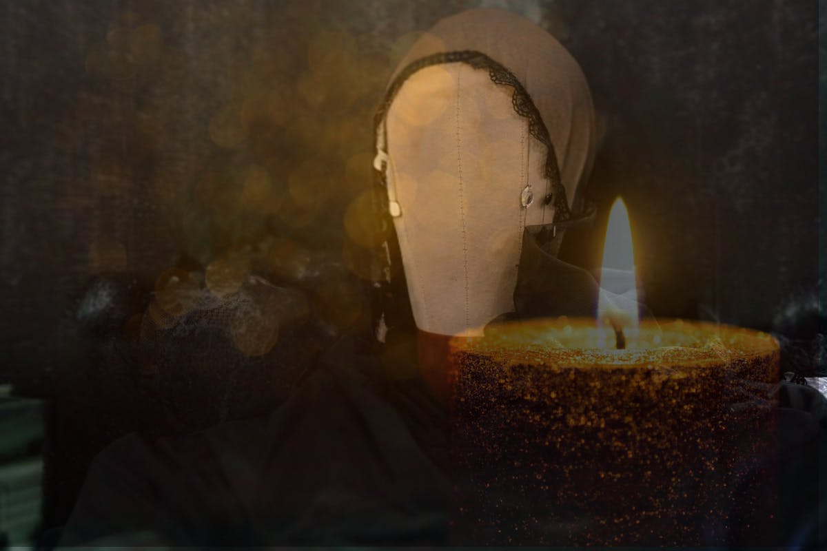 A veil on a dress form overlayed with a flickering candle for an eerie affect