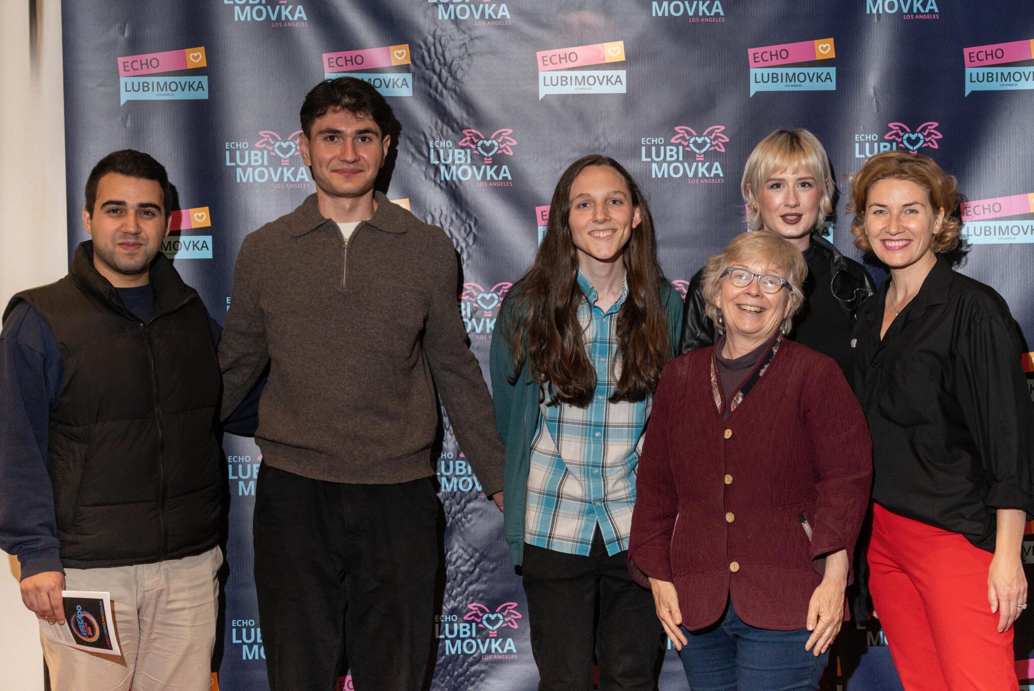 A group of UCLA students and their teacher pose together at a theater festival event