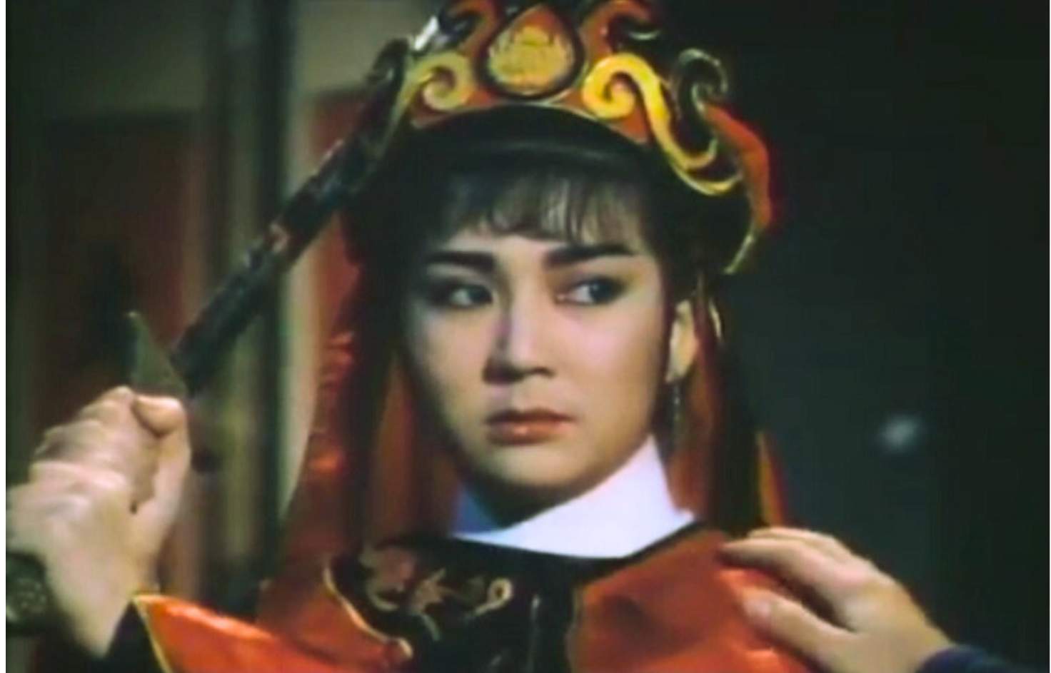 woman wearing asian head covering holding a sword