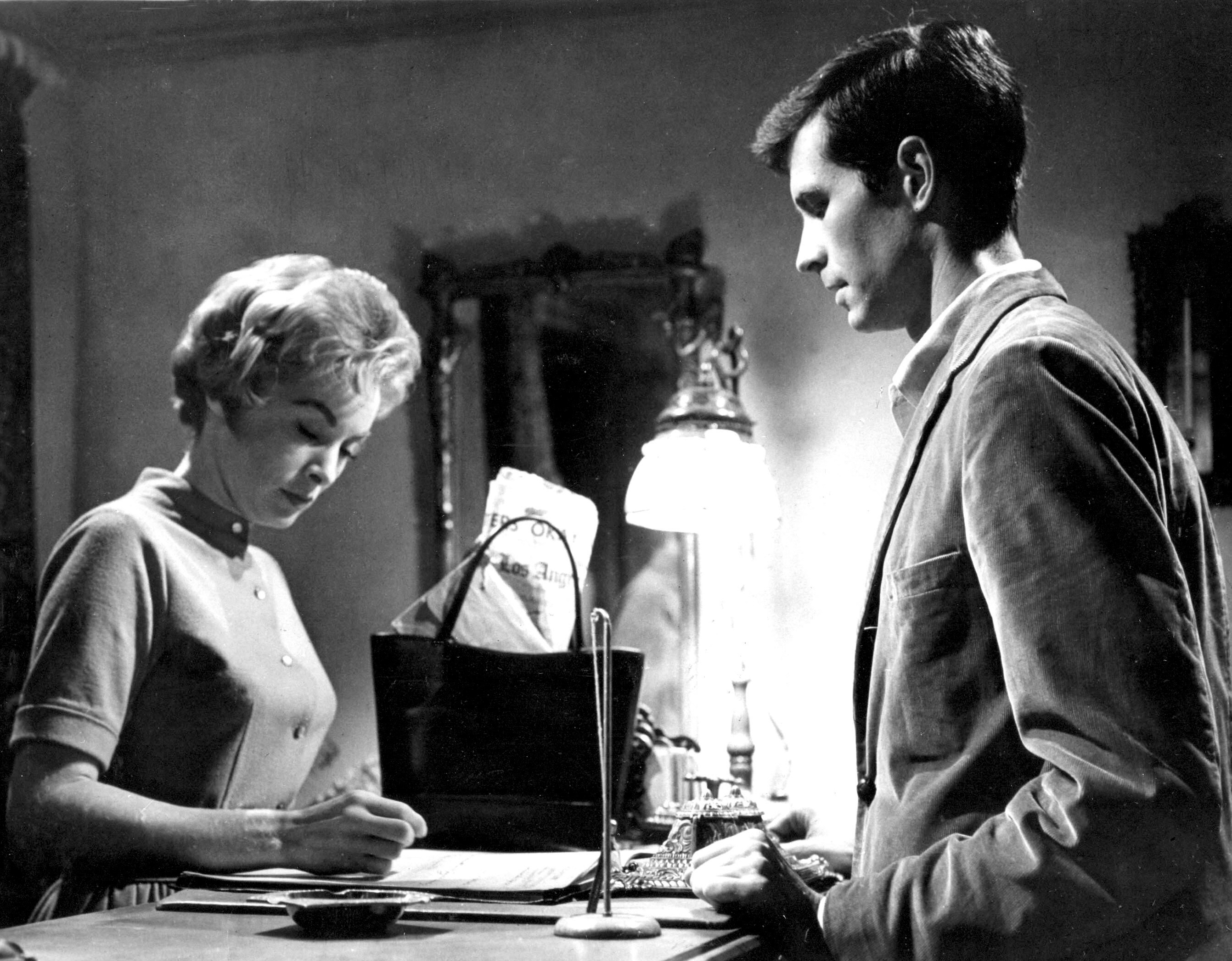 woman at a desk with man standing in front of her