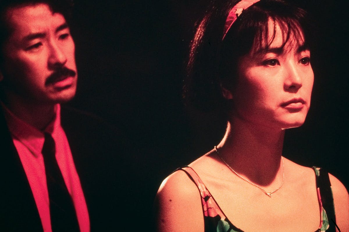 man standing behind a woman