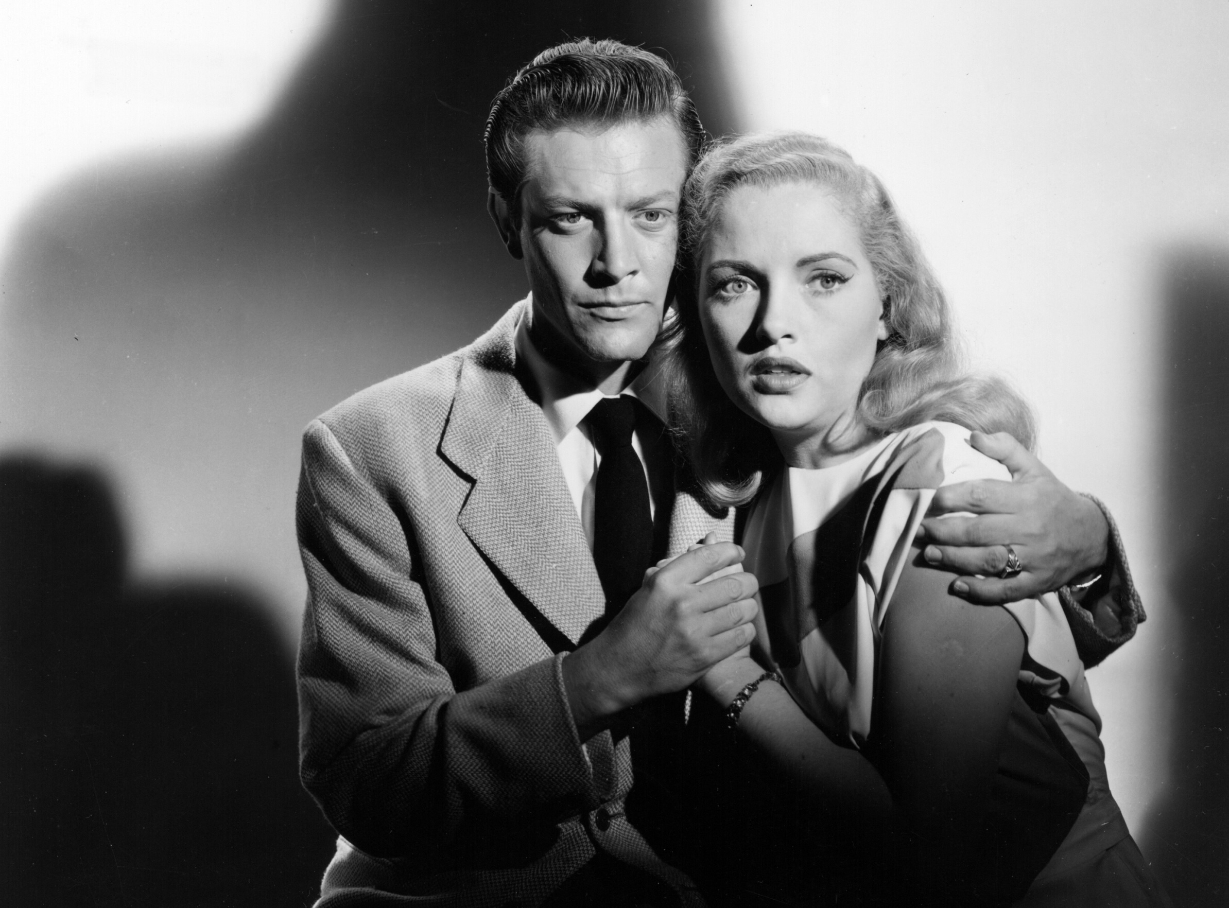 man and holding holding tightly to each other with expressions of fear