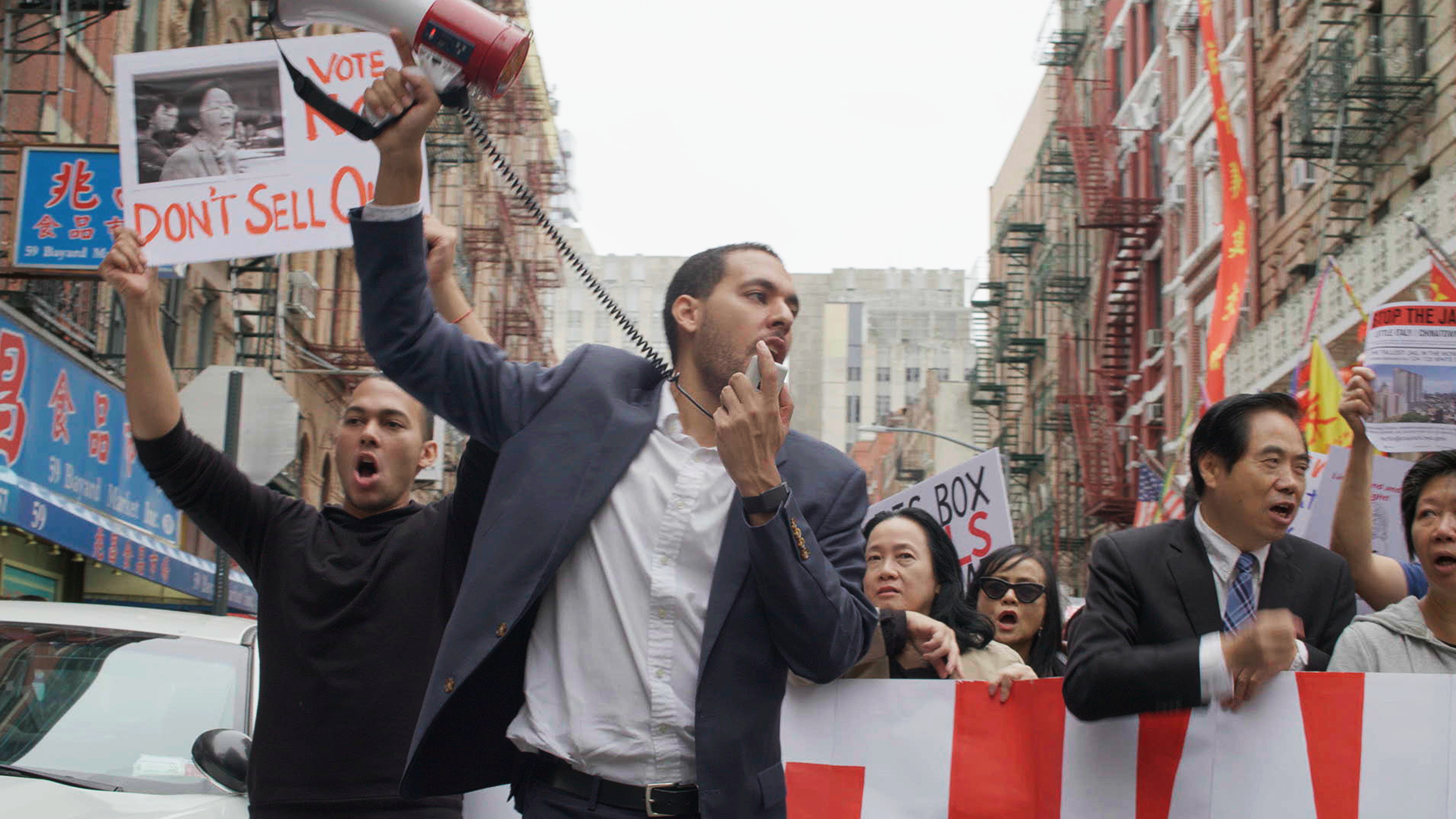 man at a protest talking into a megaphone 