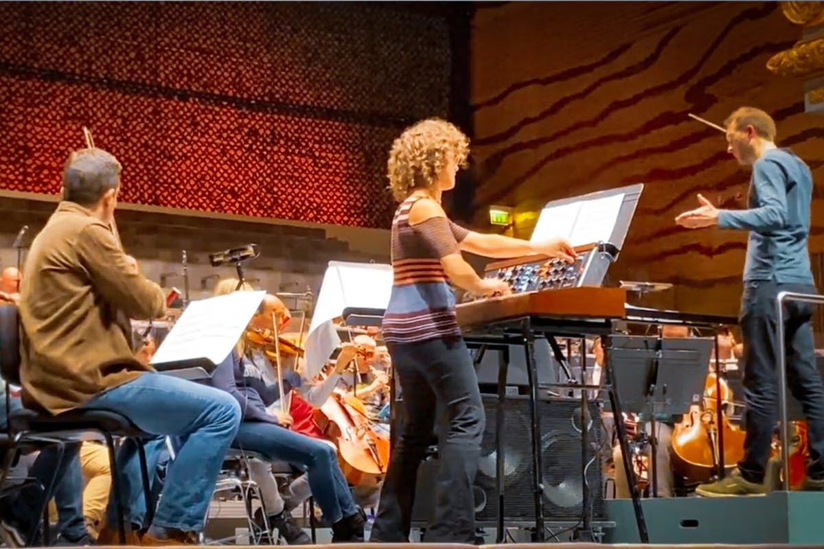Inna Faliks performs onstage with orchestra on a minimoog synthesizer