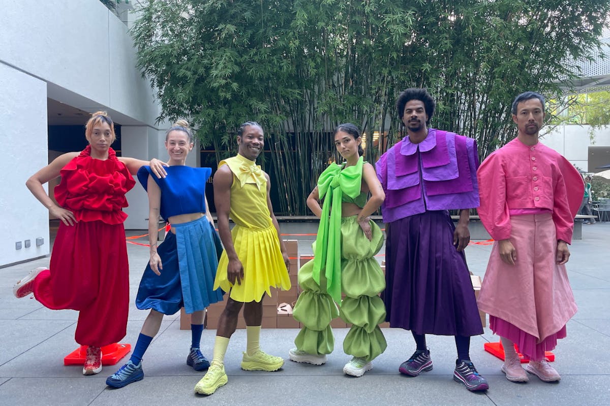 A group of performers pose in colorful costumes