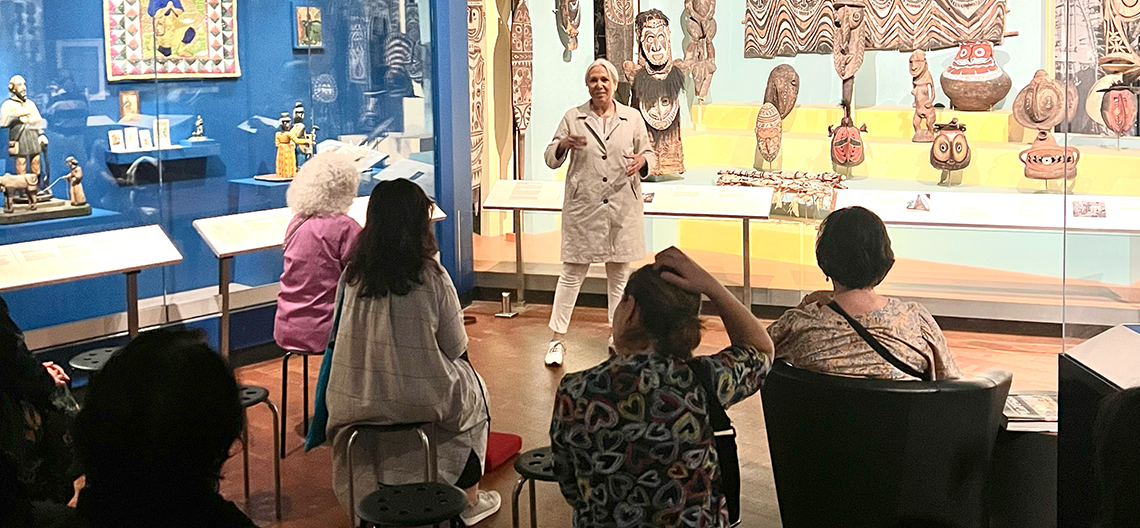 A curator talks to a group of people in the galleries of the Fowler Museum