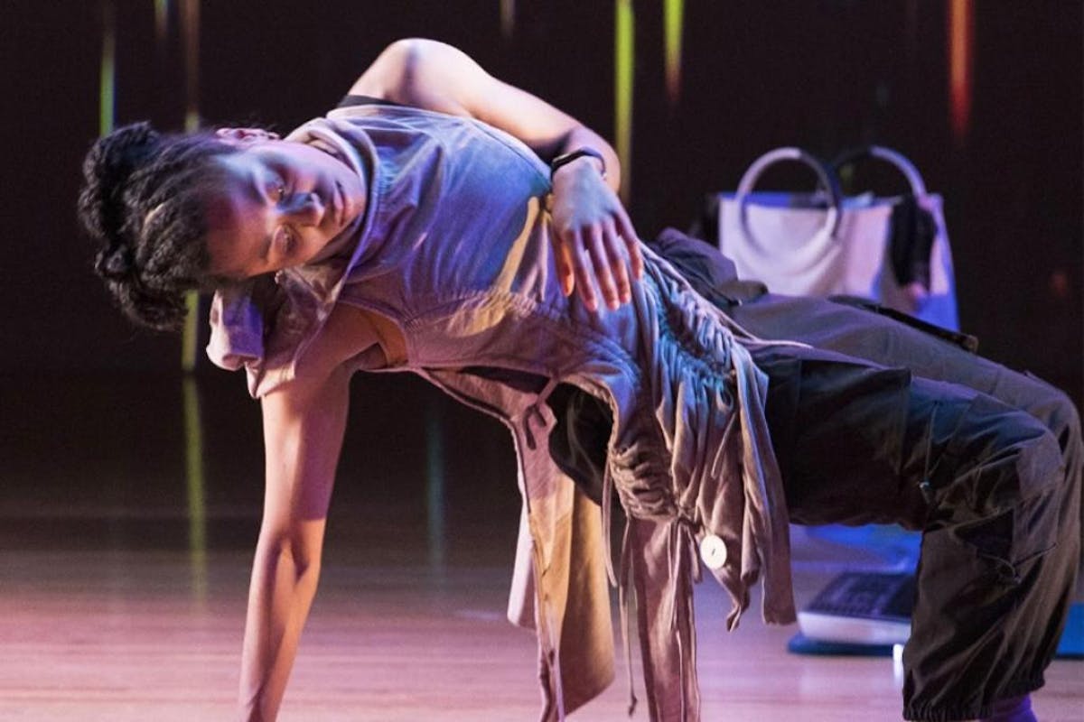 A young woman performs a movement solo on stage